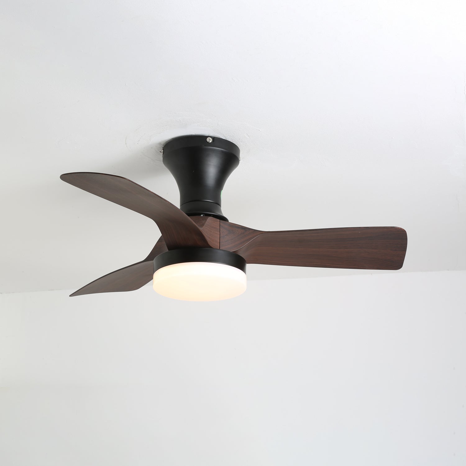 Detaillierte Ansicht der Holzmaserungsflügel und des Acrylschirms der Nora Deckenventilatorleuchte.