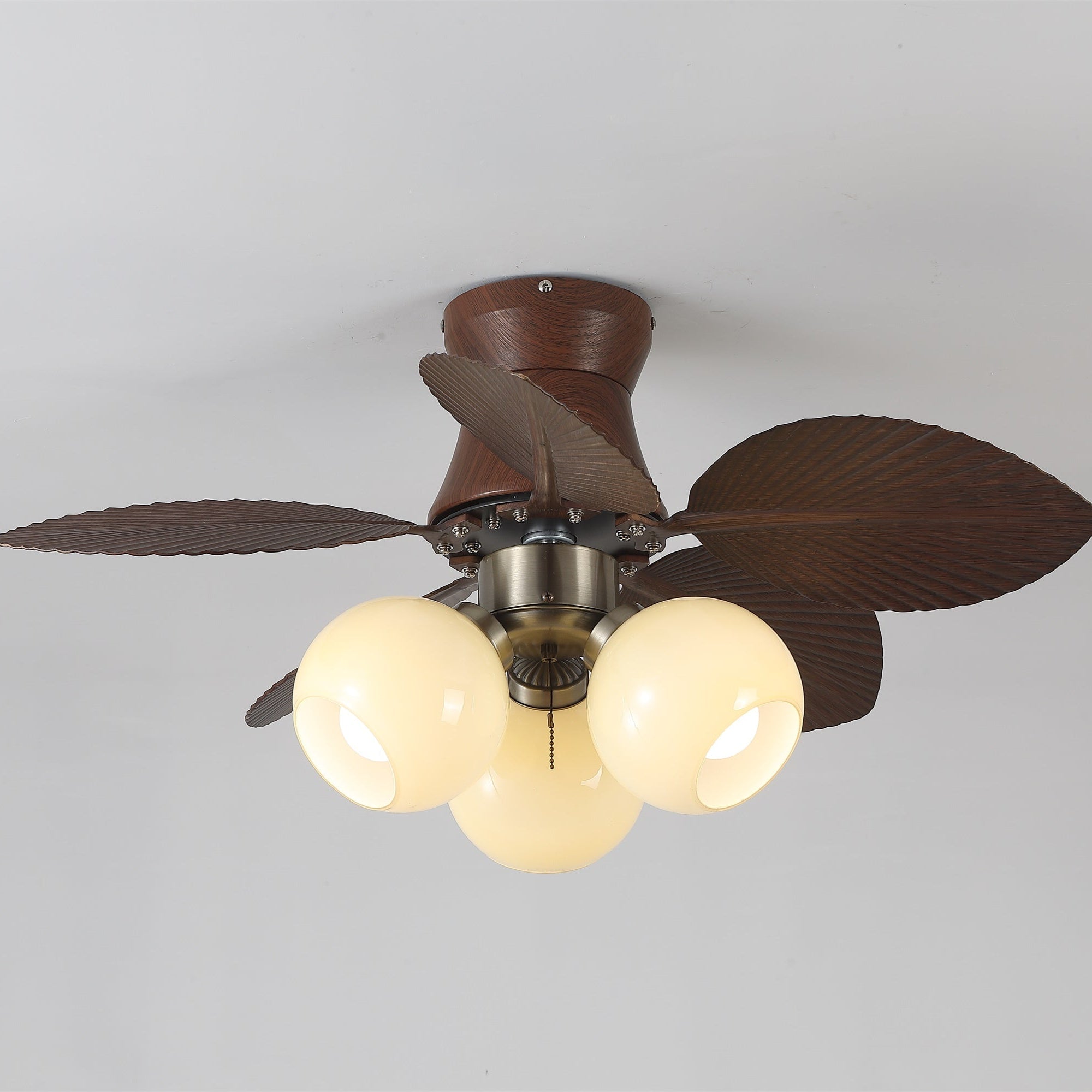 Nahaufnahme des Glaslampenschirms und Motorgehäuses des Walden Eiche Deckenventilators mit Beleuchtung